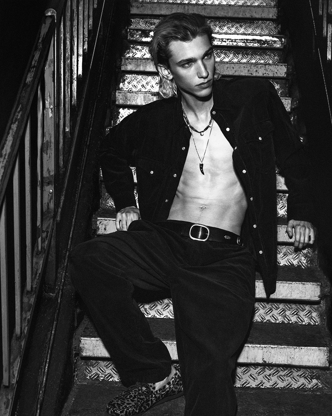 Model seats in the stairs of a club, wearing a matching outfit.