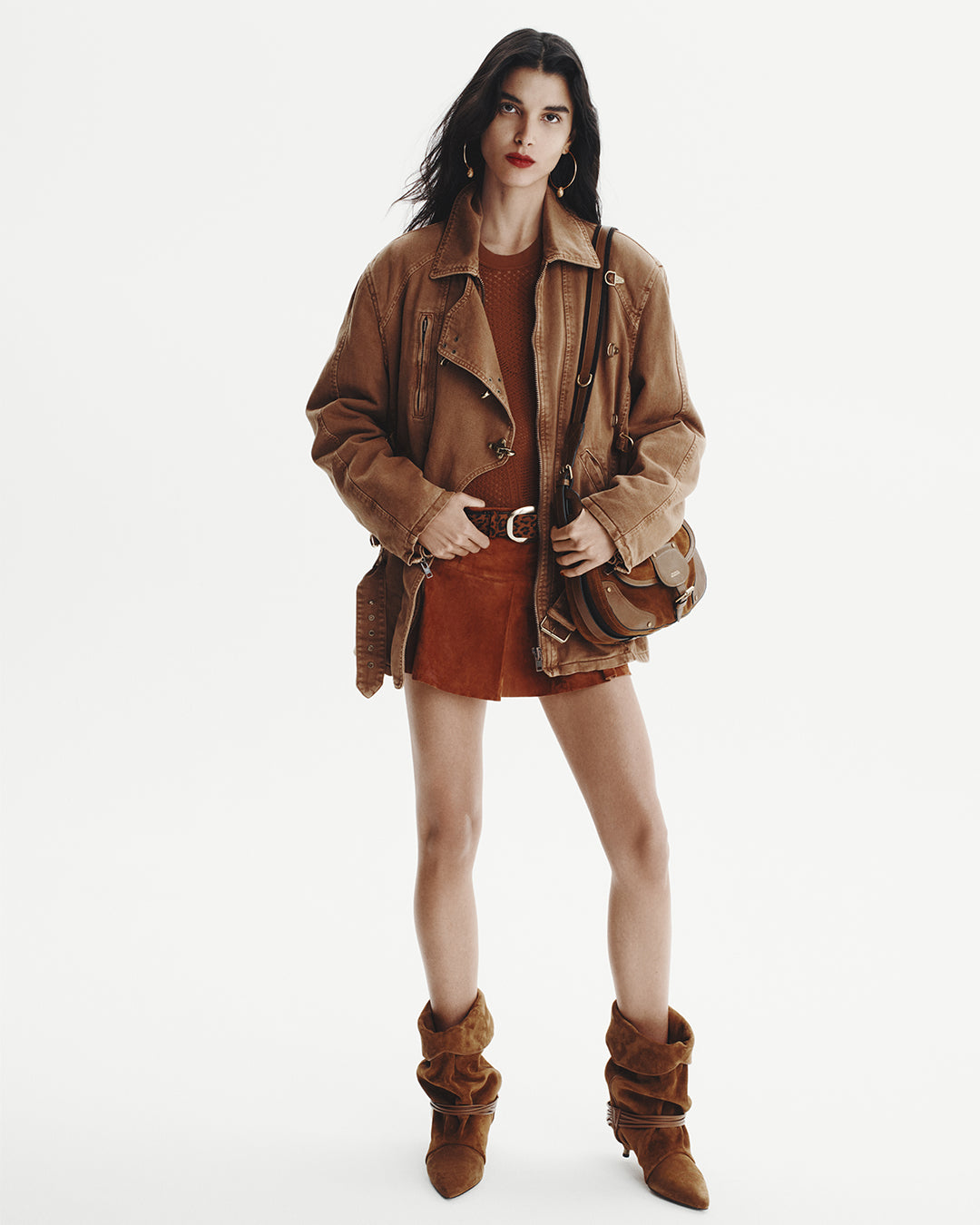 Model wears a denim brown jacket with orange top leopard printed belt and a mini skirt, Sierra Hobo bag.