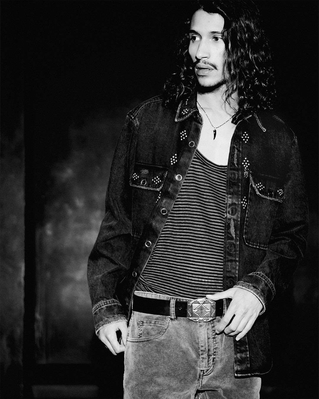 Men wearing a denim jacket with striped tank top and jeans.