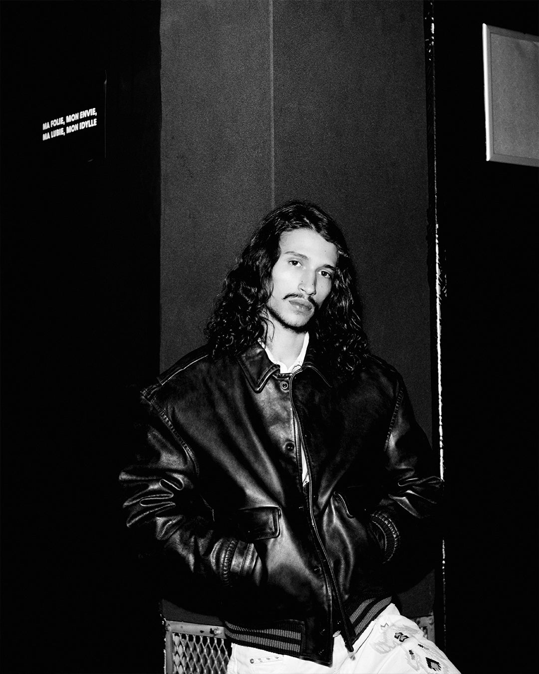 Black and white image, men model wearing a leather bomber jacket.