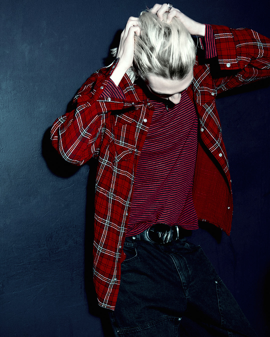 Men model wears a red checked shirt and a striped t-shirt, a cargo black pants.