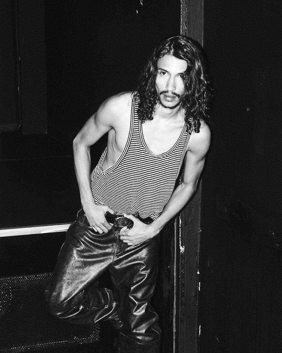 Men attitude wears a tank stripped top and leather pants.