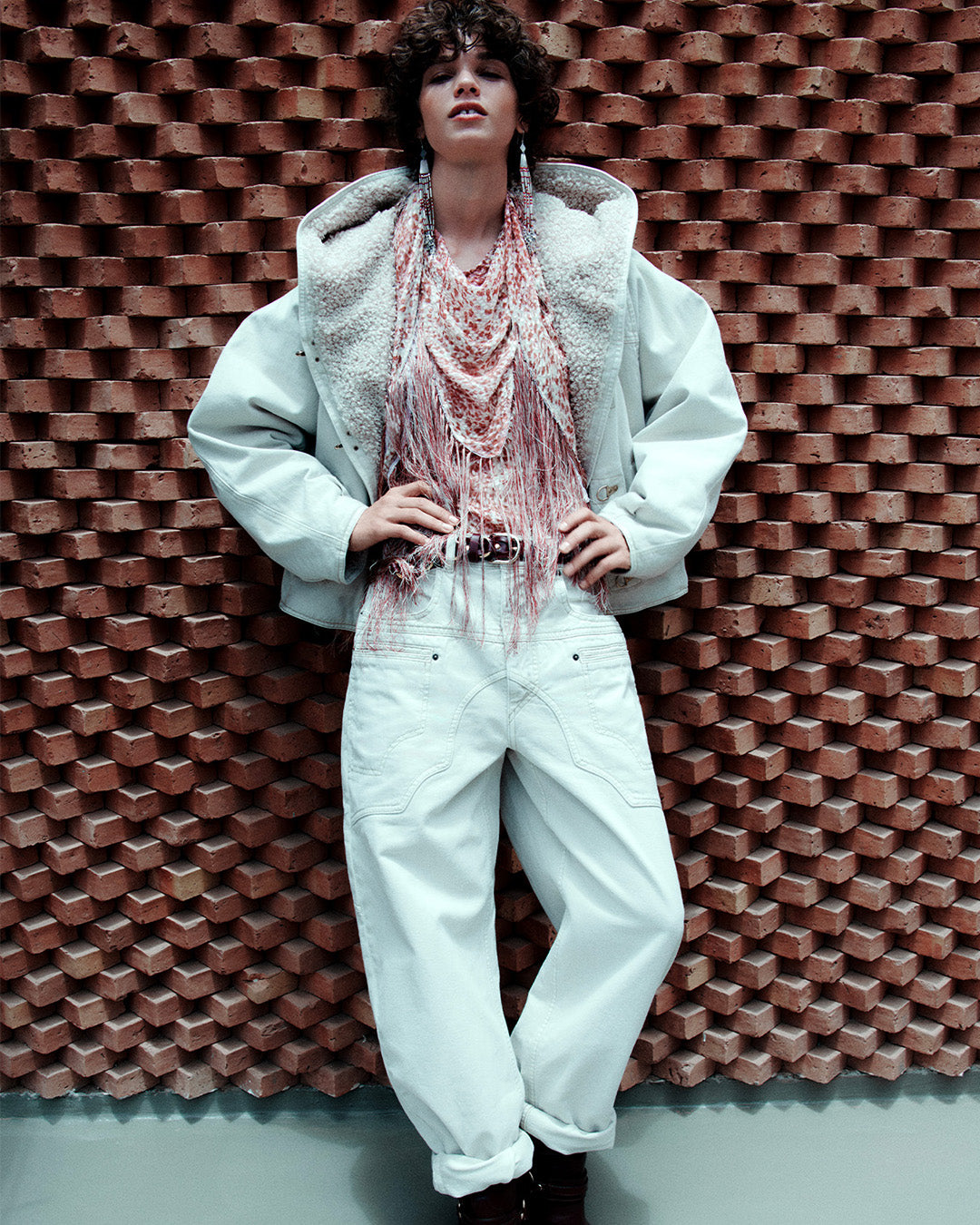 Feminine model, dressed in the Biane short coat in ecru denim, a patterned shirt, Beryl loose-fitting jeans in denim with ecru cut-outs and Lyka santiag boots in leather with black straps.