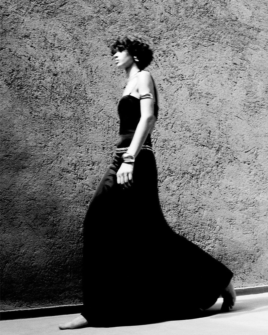 Feminine model, wearing the Kandis long dress in black satin
