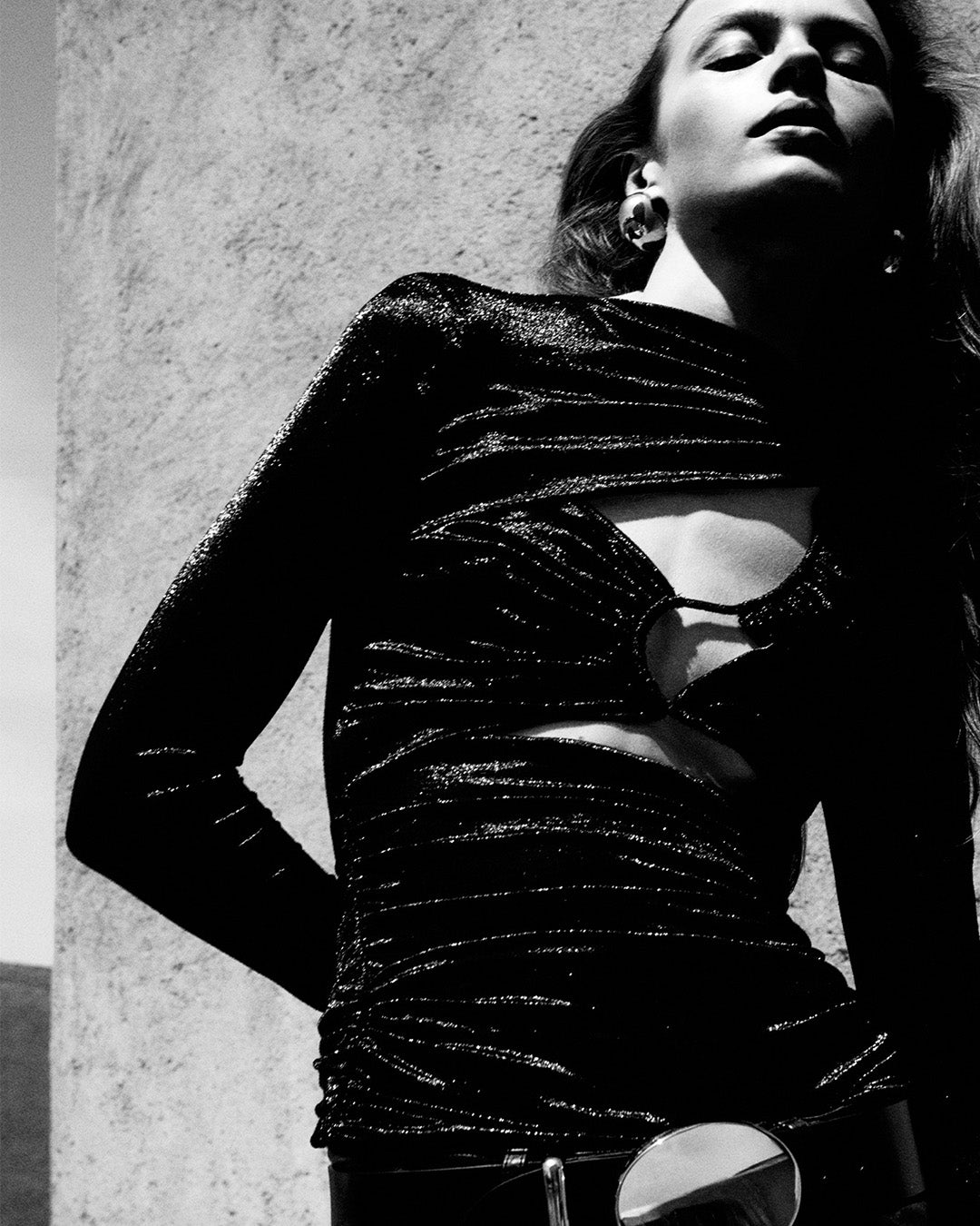 Feminine model, dressed with black top and Leonie belt