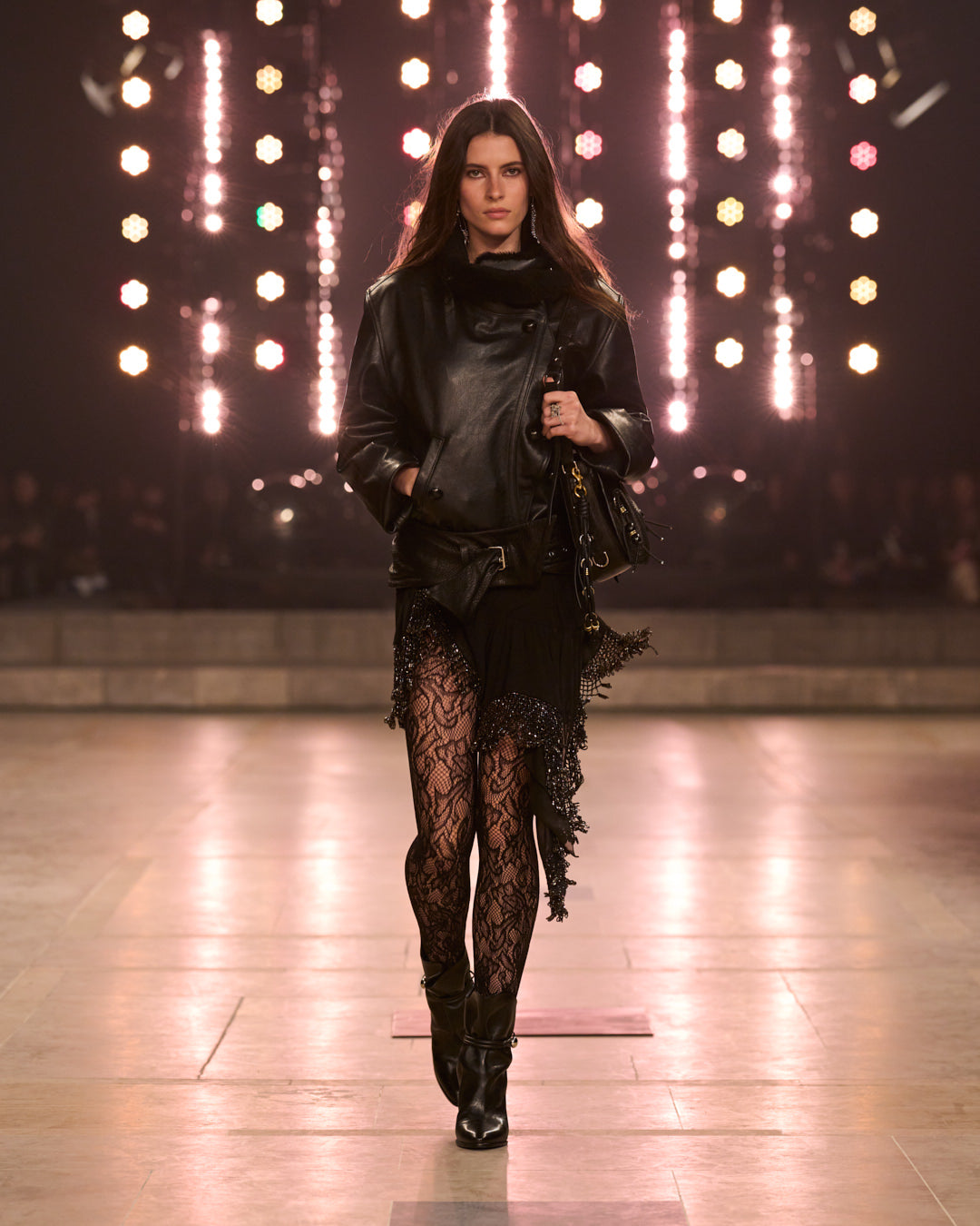 Look ( FW25 show model walking with black leather coat and dress.