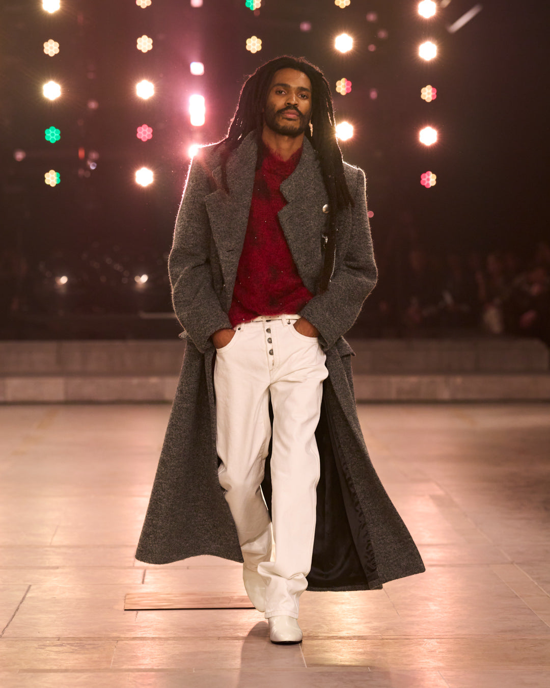 Men model walking hand in the pocket, long wool grey coat, red sweater and white pants.