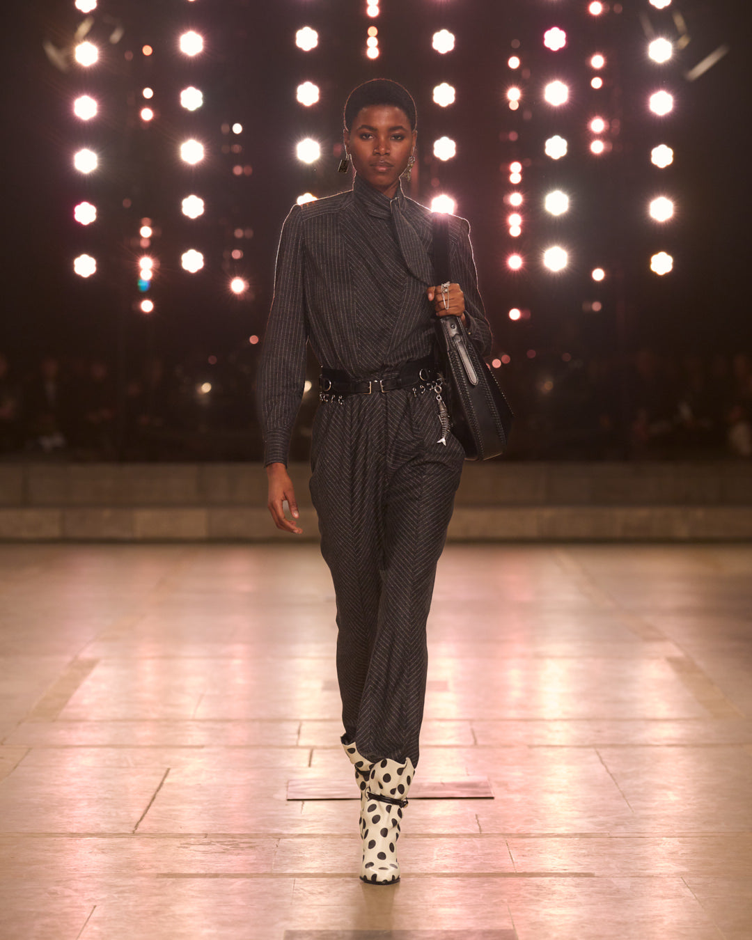Silhouette with grey striped jumpsuit, rock belt with charms.