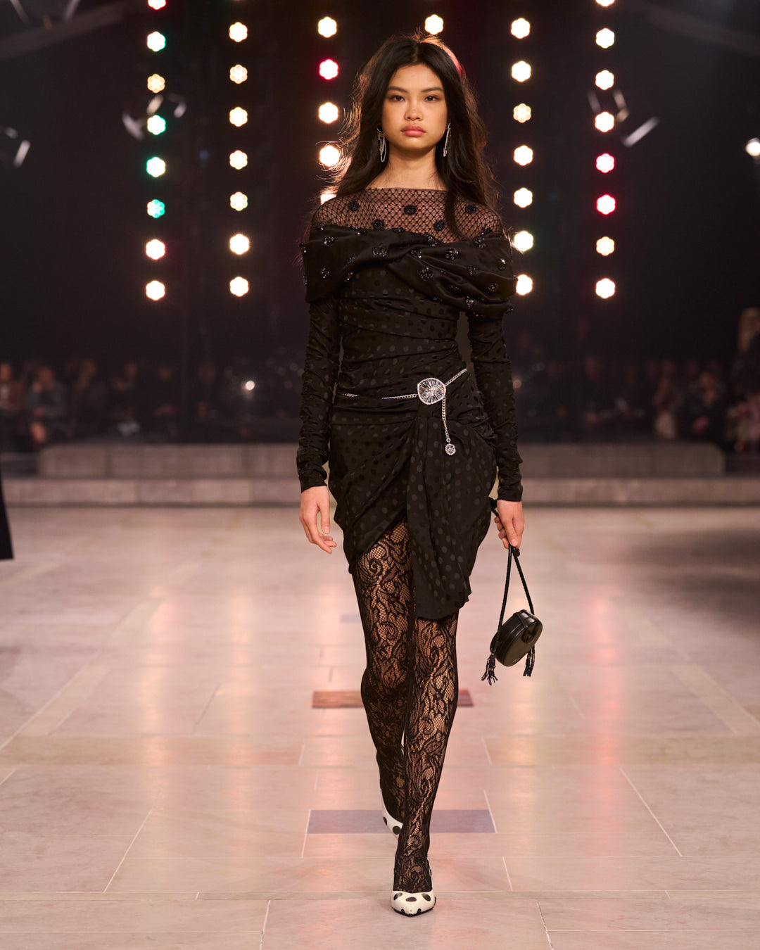 Model wears a black dress with lace and sequins.