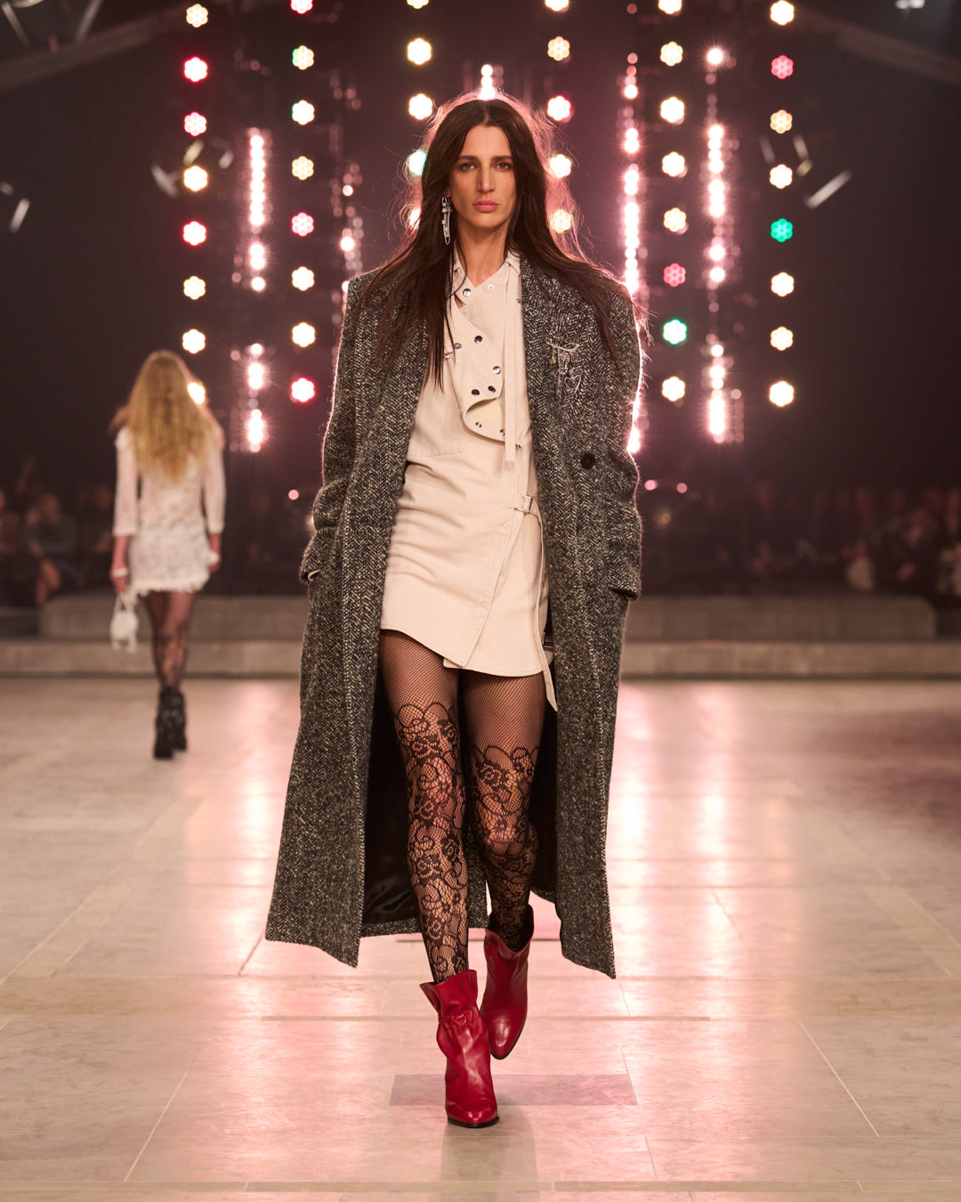 Model is wearing a white dress with a grey wool coat and red boots.