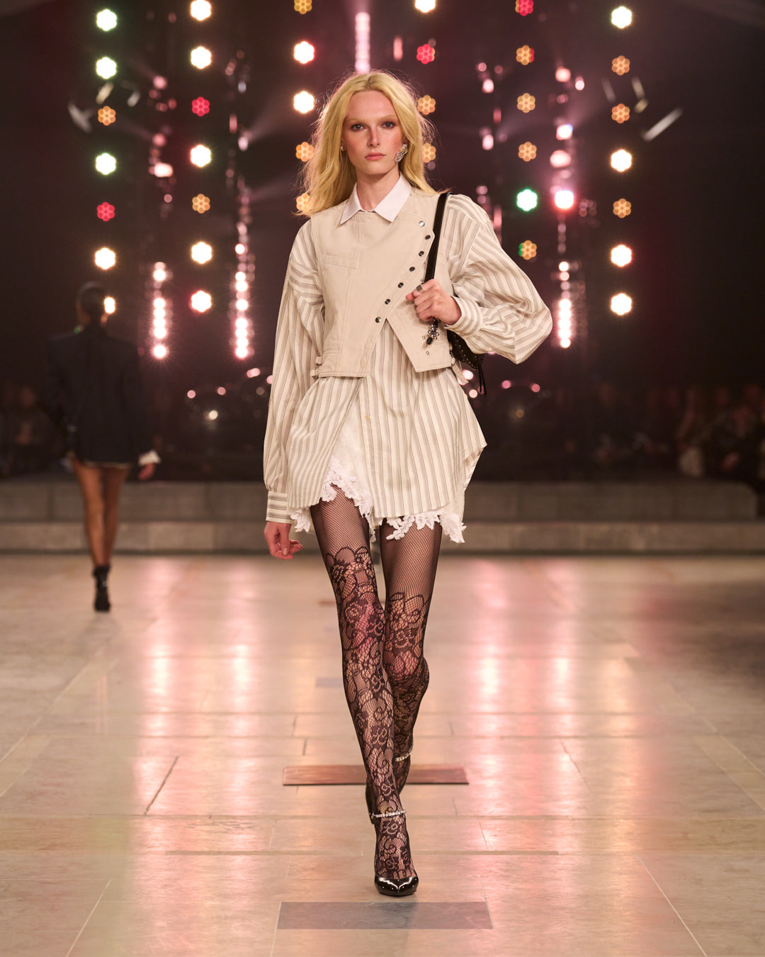 Layering of white lace dress, striped beige shirt and sleeveless beige jacket.