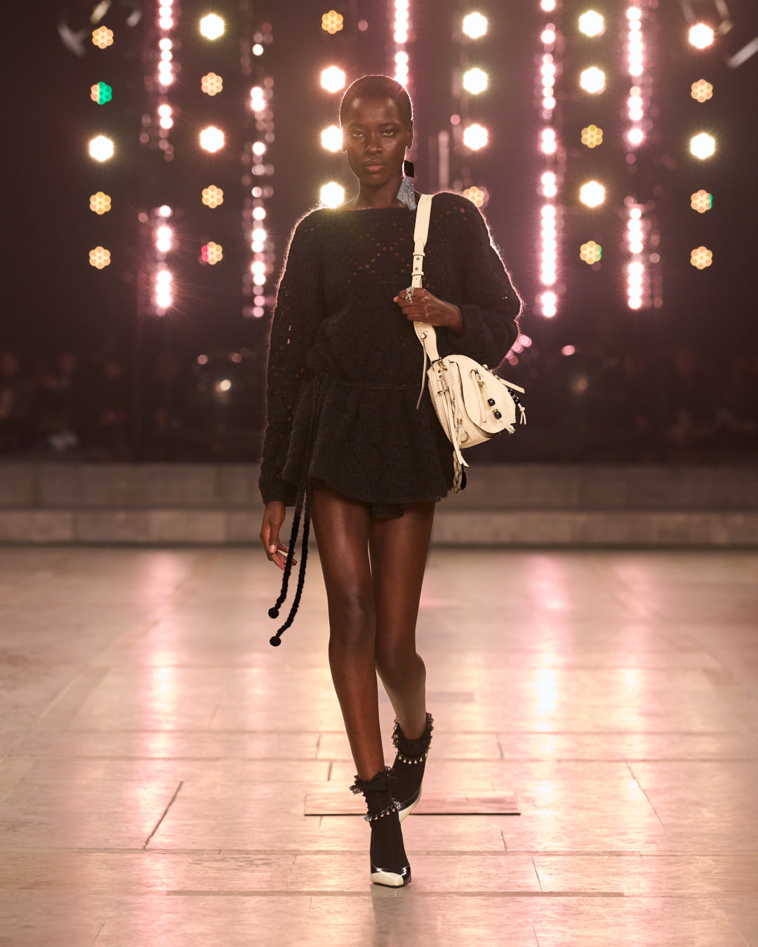 Model is walking the FW25 show with a black jumper and white leather BOLTON bag.