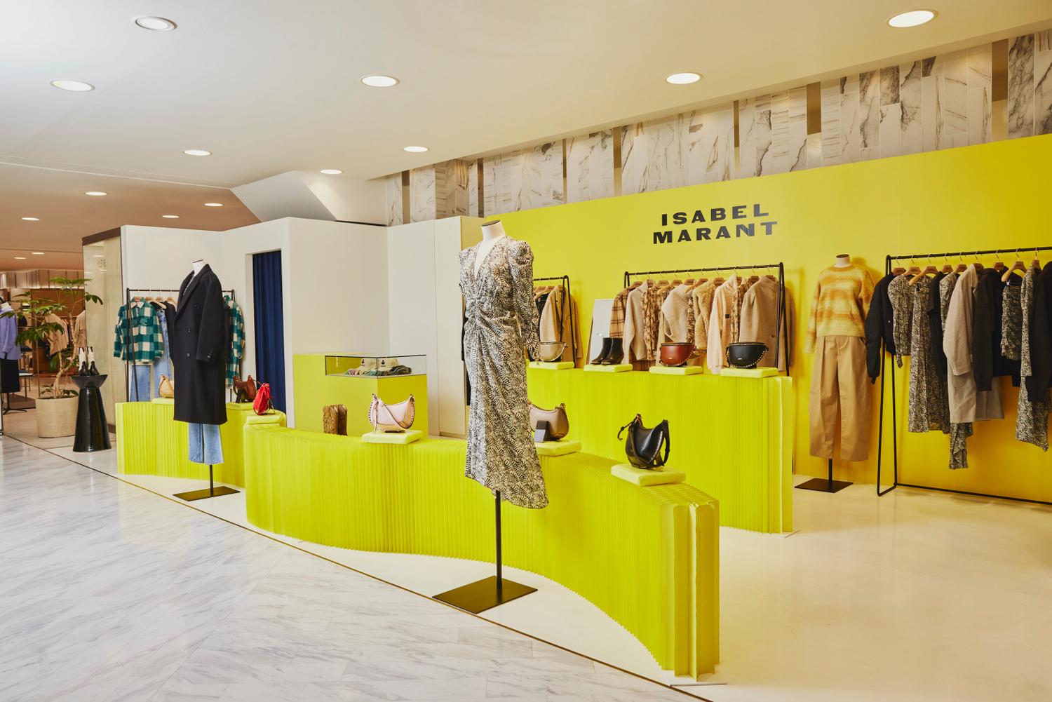 Image of yellow display area featuring the Isabel Marant clothing collection, including sweaters, pants, dresses and handbags.