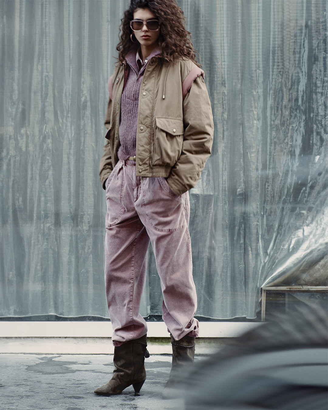 The model is wearing the Desha two-tone cotton jacket, the Danita knit crewneck sweater, the Onyta corduroy pants, and the Dalby draped calfskin suede boots.